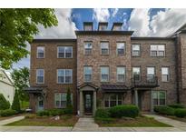 Charming brick townhome features a landscaped front yard and inviting curb appeal at 10143 Windalier Way, Roswell, GA 30076