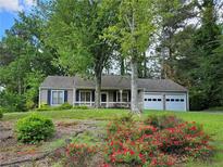 Charming single-story home with a well-maintained lawn and a two-car garage at 162 Apple Valley Dr, Woodstock, GA 30188