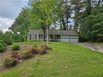 Charming single-story home featuring a well-maintained lawn and an attached two-car garage at 162 Apple Valley Dr, Woodstock, GA 30188