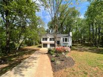 Charming two-story home featuring a well-manicured lawn, flower bed, and a double-car garage at 7160 Royston Way, Cumming, GA 30028
