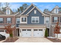 Beautiful townhouse with blue accents, brick accents, two-car garage and a paved driveway at 305 Duval Dr, Alpharetta, GA 30009