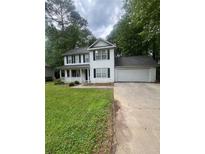 Charming two-story home features a well-manicured lawn and attached two car garage at 9866 Point View Dr, Jonesboro, GA 30238