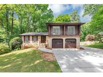Charming two-story home with a two-car garage, beautiful brickwork, and a well-manicured front yard at 563 Navarre Dr, Stone Mountain, GA 30087