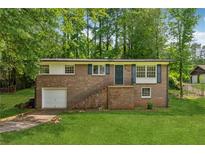 Charming brick home with a well-maintained lawn, inviting entrance, and one-car garage on a sunny day at 2015 Twelve Oaks Nw Cir, Kennesaw, GA 30144