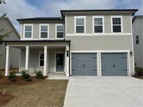 Charming two-story home featuring a two-car garage and a covered front porch at 2105 Boxwood Se Cir, Conyers, GA 30094