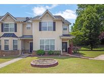 Inviting townhome featuring a well-manicured lawn and neutral-toned facade with dark shutters at 7293 Bridlewood Ct, Jonesboro, GA 30236