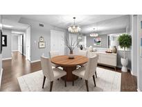 Bright dining area featuring modern chandelier, wood table, and white buffet at 6851 Ne Roswell Rd # C4, Atlanta, GA 30328