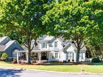 Charming two-story home with a manicured lawn and mature trees creating a picturesque curb appeal at 10635 Sugar Crest Ave, Johns Creek, GA 30097