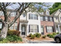 Charming townhouse with white siding, black shutters, and well-maintained landscaping at 1207 Penhurst Way, Lawrenceville, GA 30043