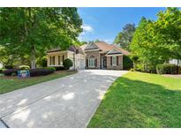 Charming home with a manicured lawn, stone accents, and a basketball hoop by the driveway, surrounded by mature trees at 931 Windsor Creek Dr, Grayson, GA 30017