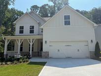 Charming two-story home with a two-car garage, covered porch, and professionally landscaped yard at 93 Riverwood Dr, Dallas, GA 30157