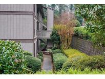 Condominium exterior with a stairway and walkway surrounded by manicured landscaping and a brick wall at 507 Embers Se Dr, Marietta, GA 30067