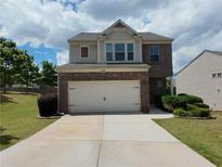 Two-story home with brick facade and attached two-car garage featuring a well-manicured lawn at 1369 Star Water Dr, Lawrenceville, GA 30045