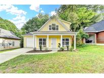 Charming yellow two-story home with a well-manicured lawn and inviting front porch at 1112 Birch Sw St, Atlanta, GA 30310