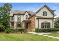 Charming two-story home with manicured lawn, stone accents, and a welcoming front porch at 4823 Layfield Dr, Dunwoody, GA 30338