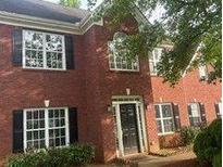 Traditional red brick home featuring a classic front door and multi-pane windows with black shutters at 602 Jules Crest Ct, Lawrenceville, GA 30045