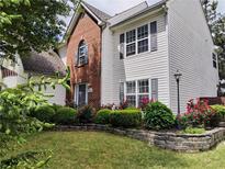 Charming two-story home with brick and white siding, complemented by a well-maintained lawn and colorful flower beds at 3060 Baymount Dr, Lawrenceville, GA 30043