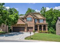 Beautiful brick two-story home featuring an attached two car garage and manicured front yard at 1185 Gallatin Way, Suwanee, GA 30024