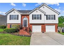 Charming two-story home featuring brick accents, black shutters and a well-manicured lawn at 995 Chimney Trace Way, Lawrenceville, GA 30045
