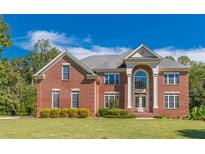 Elegant red brick home with a manicured lawn and symmetrical design, creating a welcoming and stately curb appeal at 270 Annelise Park Dr, Fayetteville, GA 30214