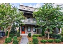 Charming two-story home with a brick facade, an inviting orange front door, and lush landscaping at 6645 Cortland Walk, Alpharetta, GA 30005
