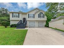 Charming split-level home featuring a two-car garage and freshly manicured lawn at 2880 Field Spring Dr, Lithonia, GA 30058