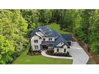 Elegant two-story brick home featuring lush landscaping, a spacious driveway, and a well-manicured lawn at 885 Old Peachtree Ne Rd, Lawrenceville, GA 30043