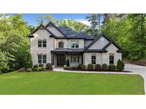 Stunning two-story brick home features a lush lawn and manicured landscaping at 885 Old Peachtree Ne Rd, Lawrenceville, GA 30043