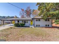 Charming single-Gathering home with a well-maintained front yard and bright yellow front door at 2103 Columbia Dr, Decatur, GA 30032