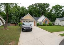 Charming single-story home with a well-manicured lawn and a paved driveway at 2840 General Lee Way, Buford, GA 30519