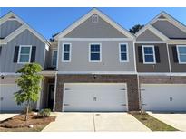 Charming townhome showcasing a brick front, complemented by a two-car garage and well-manicured landscaping at 7621 Gray Pointe Dr, Lithonia, GA 30058