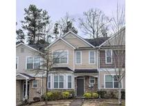 Traditional townhouse exterior featuring beige siding, multi-pane windows, and well-maintained landscaping at 2366 Bigwood Trl, Atlanta, GA 30349