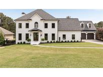 Stunning white painted brick home featuring manicured lawn and three car garage at 2211 Lattimore Farm Nw Dr, Kennesaw, GA 30152