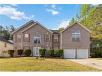 Traditional two-story brick home with a well-manicured lawn, double garage and classic architectural details at 6252 Selborn Sw Dr, Atlanta, GA 30331