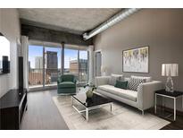 Stylish living room featuring hardwood floors, city views, and modern furniture at 943 Peachtree Ne St # 1010, Atlanta, GA 30309