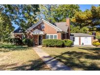 Charming brick home with a well-manicured lawn and an inviting walkway leading to the front door at 2896 Toney Dr, Decatur, GA 30032