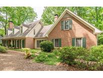 Charming brick home featuring green shutters and a well-manicured lawn, creating a warm and inviting curb appeal at 335 Cameron Ridge Dr, Atlanta, GA 30328
