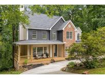 Charming two-story home with a welcoming front porch and a mix of stone and siding accents at 5560 Pilgrim Point Ext, Cumming, GA 30041