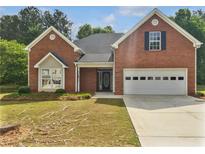 Charming brick home featuring a two-car garage and well-maintained front yard at 30 Trelawney Ct, Covington, GA 30016
