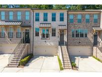 Beautiful townhome exterior with brick facade, front-entry garage, and well maintained landscaping at 3982 Carver Cir, Doraville, GA 30360