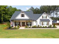 Charming white farmhouse with a welcoming front porch, dark shutters, and lush green lawn at 62 Presley Farm Pkwy, Rockmart, GA 30153