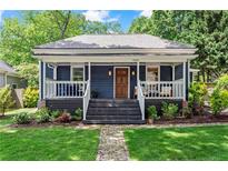 Charming home featuring a welcoming front porch, wood door, landscaped front yard, and fresh curb appeal at 2647 Forrest Nw Ave, Atlanta, GA 30318