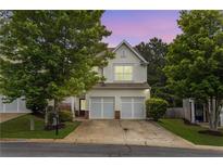 Charming townhome featuring a two-car garage, neutral siding, and professionally maintained landscaping at 720 Mountain Laurel Dr, Canton, GA 30114