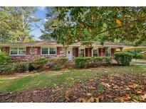 Charming single-story brick home featuring a covered carport, well-manicured landscaping, and inviting curb appeal at 4074 Idlevale Dr, Tucker, GA 30084