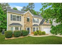 Charming two-story home featuring a well-maintained lawn and manicured shrubbery at 6297 Polar Fox Ct, Riverdale, GA 30296