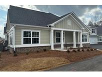 Charming single-story home featuring a covered porch, manicured landscaping, and neutral color palette at 1001 Calypso Way # 1001, Cumming, GA 30040