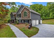 Charming home featuring stone accents, gray siding, and a well-manicured lawn at 3232 Watson Mill Dr, Loganville, GA 30052