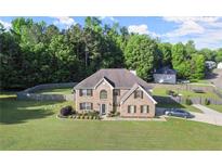 Charming two-story brick home with a well-manicured lawn and mature trees at 423 Blackbird Way, Hampton, GA 30228