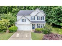 Charming two-story home boasts a manicured lawn, two-car garage, and inviting curb appeal with white siding and blue shutters at 2022 Maple Ridge Nw Dr, Acworth, GA 30101