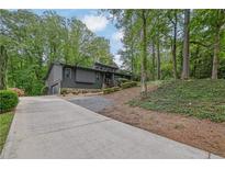 Contemporary home featuring a stylish exterior, two-car garage, landscaped front yard, and a lengthy concrete driveway at 3165 Brookview Dr, Marietta, GA 30068